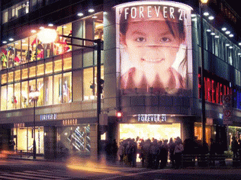 A Store Front With A Large Billboard That Says Forever 21 On It GIF