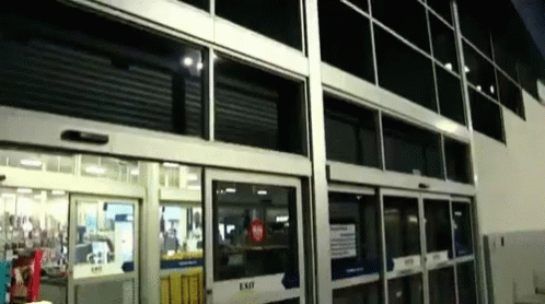 A Store Front With A Sliding Glass Door That Says Exit GIF