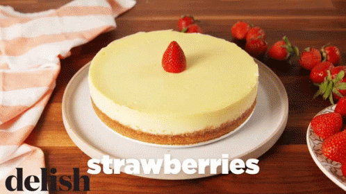 A Strawberry Cheesecake On A White Plate With The Words Delish Strawberries GIF