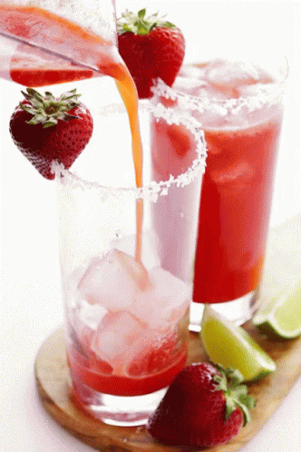 A Strawberry Margarita Being Poured Into A Glass With Ice GIF