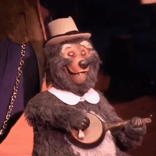A Stuffed Animal Bear Is Playing A Banjo And Smiling GIF