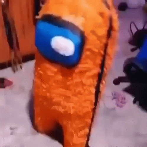 A Stuffed Animal Dressed As An Orange Among Us Character With A Blue Head . GIF