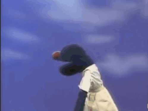 A Stuffed Animal Is Holding A Football In Its Mouth . GIF