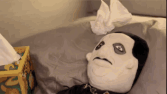 A Stuffed Animal Is Laying On A Bed With A Box Of Kleenex Next To It GIF