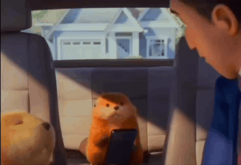 a stuffed animal is sitting in the back seat of a car with a man looking at it