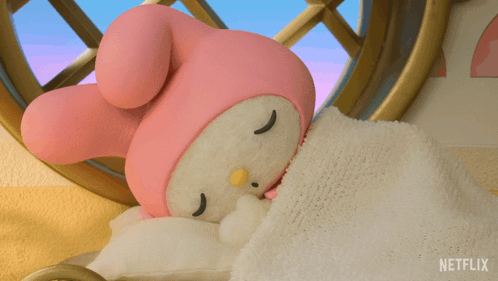 A Stuffed Animal Sleeping On A Bed With A Blanket That Says Netflix GIF
