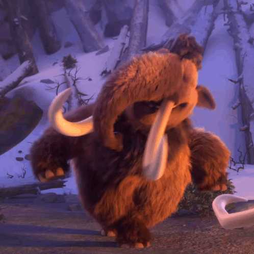A Stuffed Animal That Looks Like An Elephant With Tusks Standing In The Snow GIF
