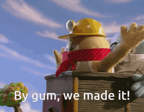 A Stuffed Animal Wearing A Yellow Hard Hat And Scarf Says By Gum We Made It GIF