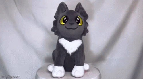 A Stuffed Animal With A Heart On Its Chest Is Sitting On Top Of A Table . GIF