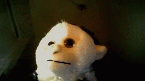A Stuffed Animal With A Sad Face Is Sitting On A Table GIF