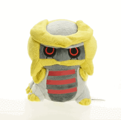 A Stuffed Animal With A Yellow Head And Red Eyes Is Sitting On A White Surface GIF