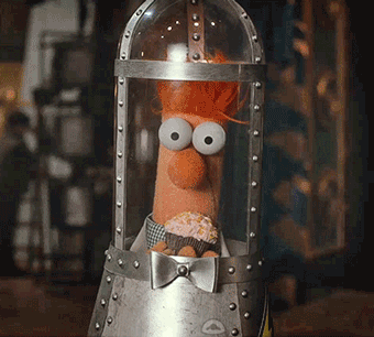 A Stuffed Animal With Big Eyes And A Cupcake In His Mouth GIF