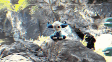 a stuffed animal with horns sits on a rock