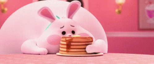 A Stuffed Bunny Is Eating A Stack Of Pancakes . GIF