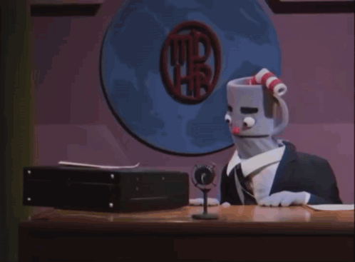 A Stuffed Cuphead Is Sitting At A Desk In Front Of A Computer Screen GIF