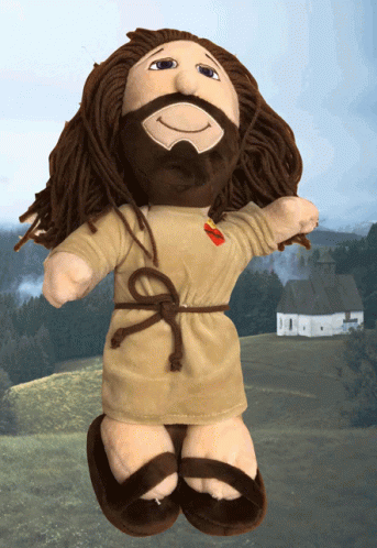 A Stuffed Doll Of Jesus Is Standing In Front Of A Field GIF