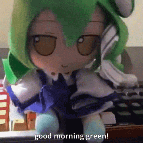 A Stuffed Doll With Green Hair Is Sitting In Front Of A Keyboard And Says " Good Morning Green " GIF