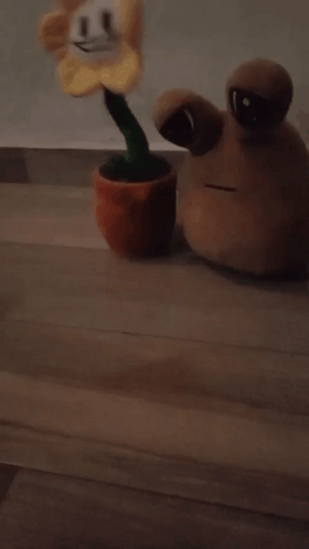A Stuffed Flower With A Green Stem Is Laying On The Floor GIF