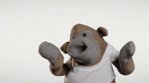 A Stuffed Gorilla Wearing A White T-Shirt And Mittens GIF