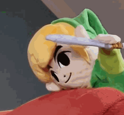 A Stuffed Link Is Holding A Knife In His Hand . GIF