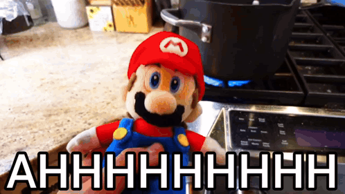 A Stuffed Mario Sitting On A Stove With The Words Ahhhh Written Below Him GIF