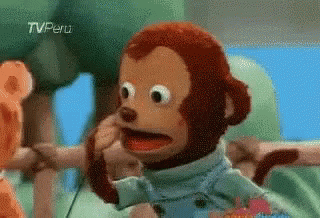 A Stuffed Monkey Is Making A Funny Face While Sitting In A High Chair . GIF