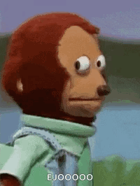 A Stuffed Monkey Is Making A Funny Face While Wearing A Green Shirt And Overalls . GIF