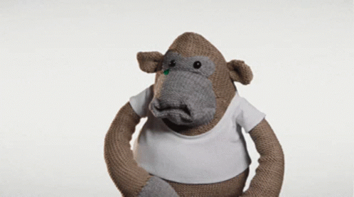 A Stuffed Monkey Wearing A White T-Shirt Looks Confused GIF