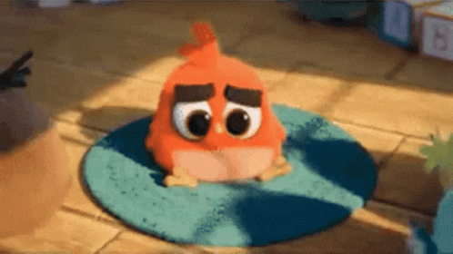 A Stuffed Orange Bird Is Sitting On A Blue Rug On The Floor . GIF