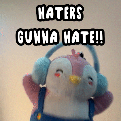 A Stuffed Penguin Wearing Ear Muffs And Overalls Says Haters Gunna Hate GIF