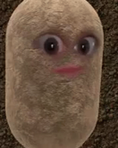 A Stuffed Potato With Big Eyes And A Red Lip Is Sitting On A Carpet . GIF