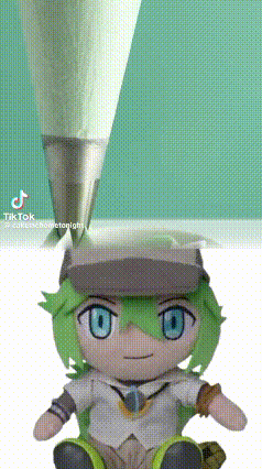 A Stuffed Toy With Green Hair And Blue Eyes Is Sitting Next To A Pencil . GIF