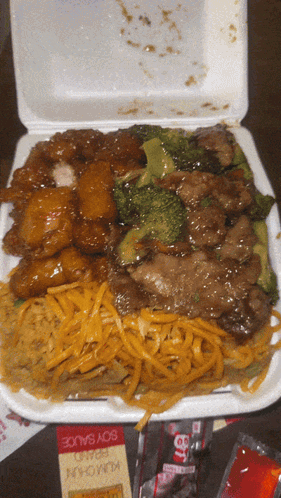 A Styrofoam Container Filled With A Variety Of Food Including Noodles And Broccoli GIF