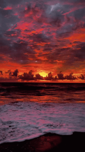 A Sunset Over A Body Of Water With A Few Clouds GIF