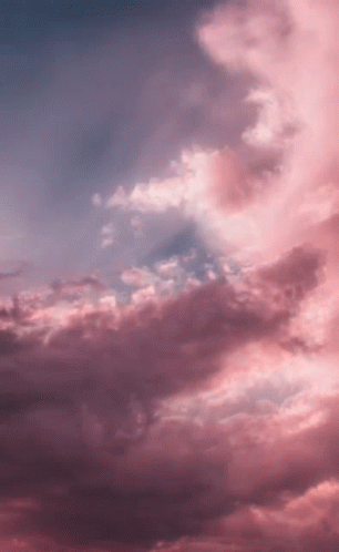 A Sunset With Pink Clouds In A Blue Sky . GIF