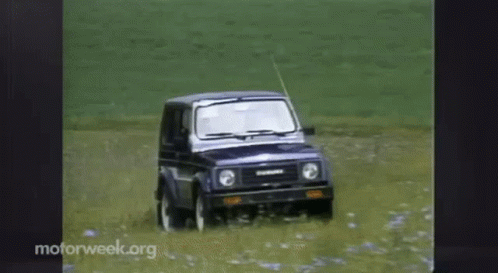 A Suzuki Suv Is Driving Through A Field Of Water GIF