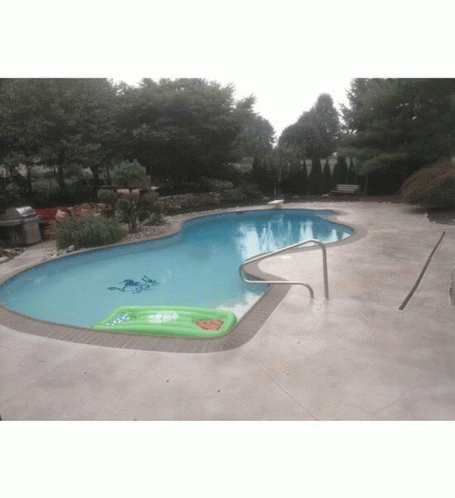 A Swimming Pool With A Green Raft In The Middle Of It GIF