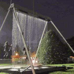 A Swing Set With Water Coming Out Of It GIF