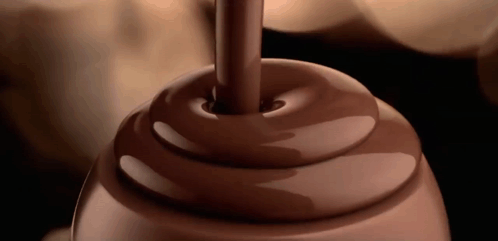 A Swirl Of Chocolate Is Being Poured Into A Container GIF