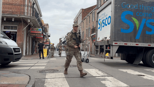 A Sysco Truck Is Driving Down A Busy Street GIF