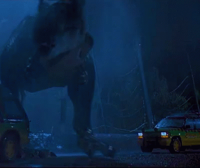 A T-Rex Is Standing In Front Of A Car That Says ' Jurassic Park ' On The Side GIF