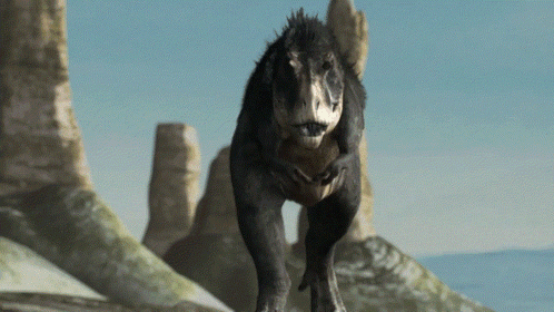 A T-Rex Is Walking Across A Rocky Landscape GIF