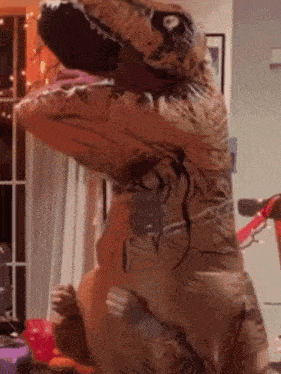 A T-Rex With Its Mouth Open Is Standing In A Living Room GIF
