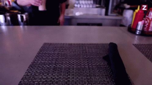 A Table With A Napkin On It And A Bottle Of Ketchup And Mustard With The Letter Z On It GIF