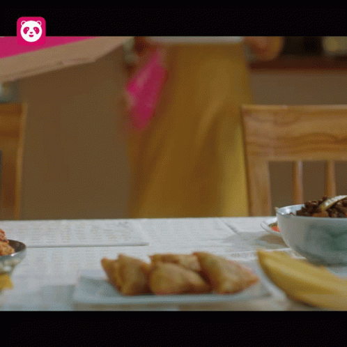 A Table With Food And A Pink Panda Logo GIF
