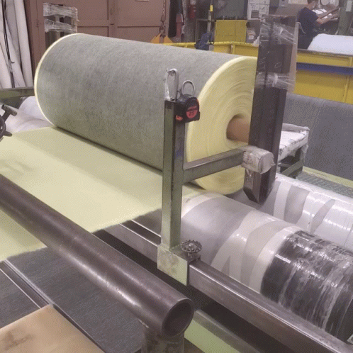 A Tape Measure Sits On Top Of A Roll Of Foam GIF