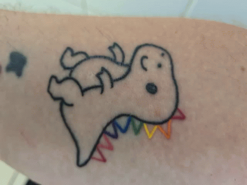 A Tattoo Of A Dinosaur With A Rainbow Tail On A Person 'S Arm GIF