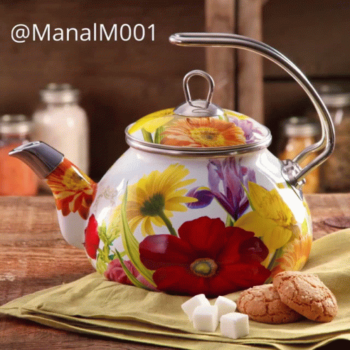 A Teapot With Flowers Painted On It Sits On A Table GIF