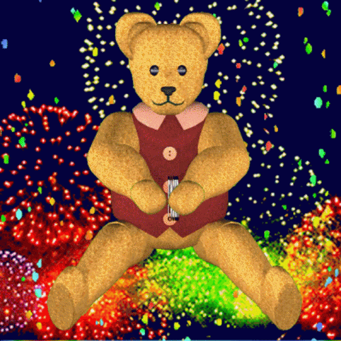 A Teddy Bear In A Red Vest Is Sitting In Front Of Fireworks GIF