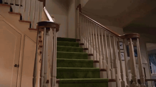 A Teddy Bear Is Falling Down A Set Of Green Stairs GIF
